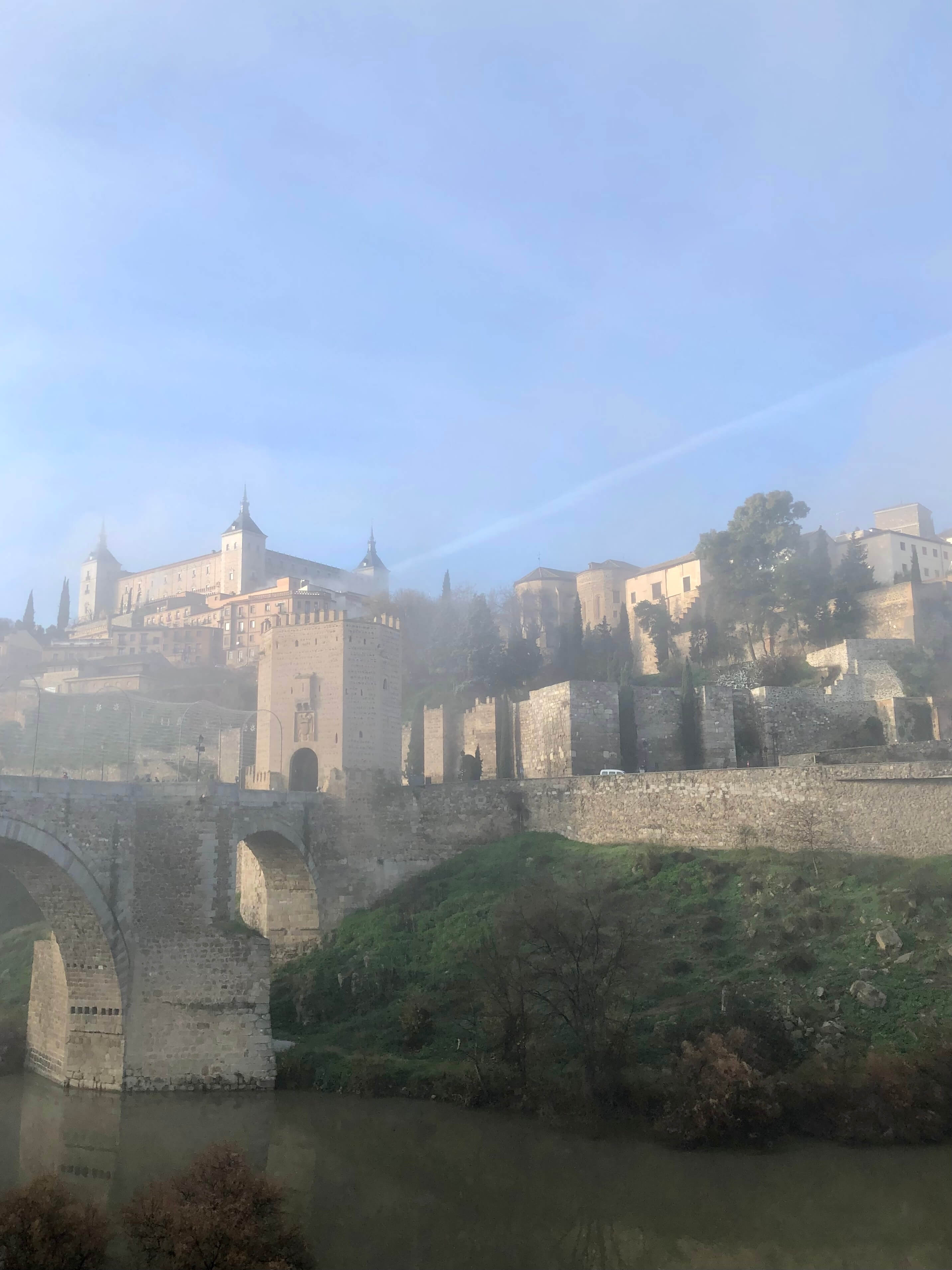 Entering the walled city of Toledo on a foggy morning